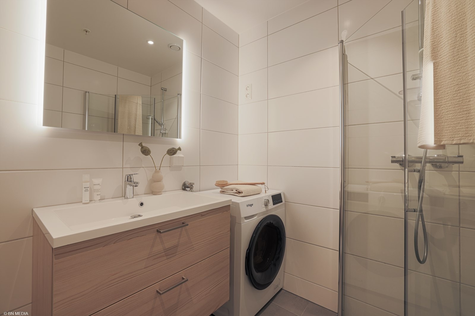 Baderomsinnredningen er moderne, med brune fronter med romslige skuffer og en heldekkende servant. Galleribilde