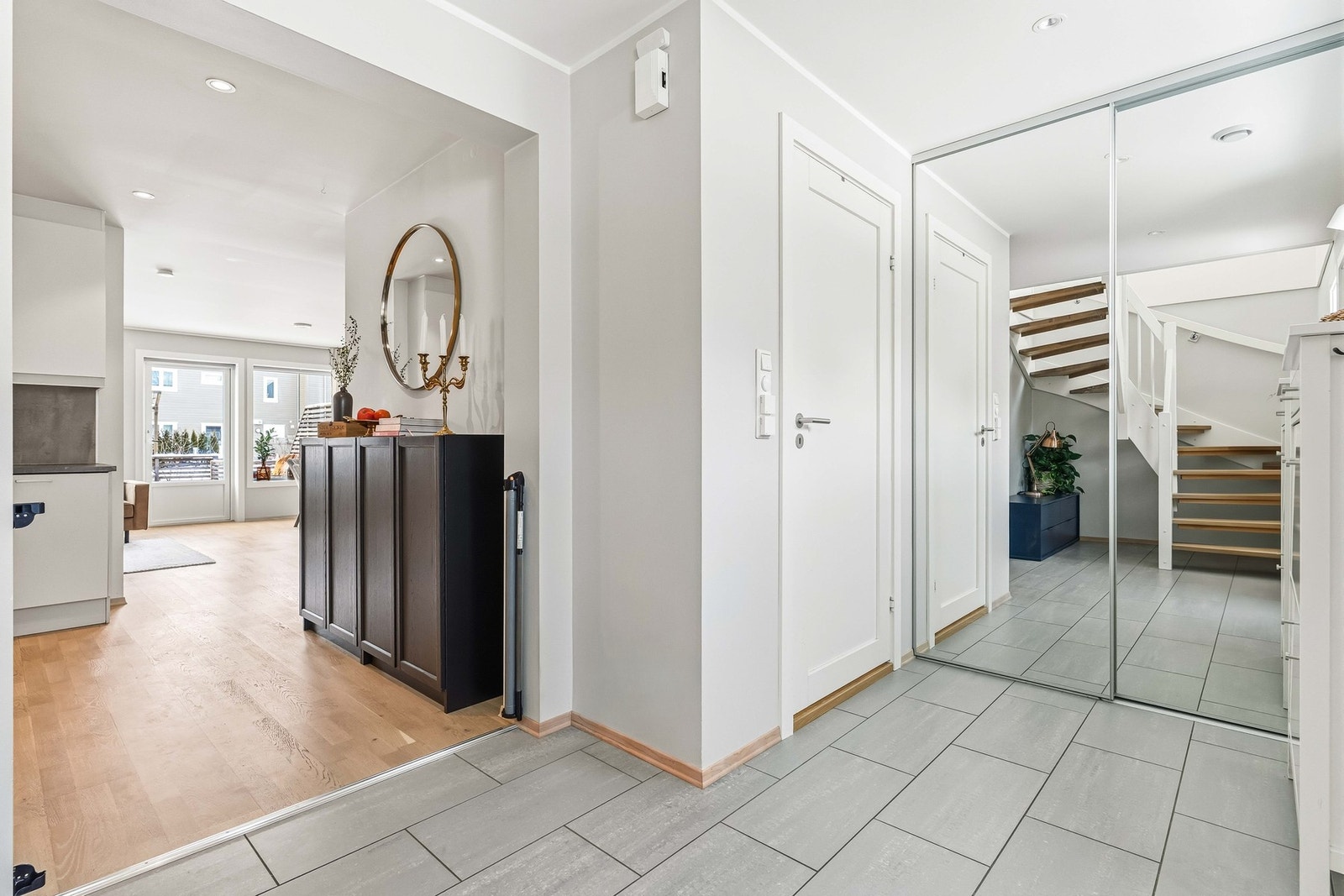 Lys og innbydende entre/hall med storformatfliser på gulv og behagelig gulvvarme. Galleribilde