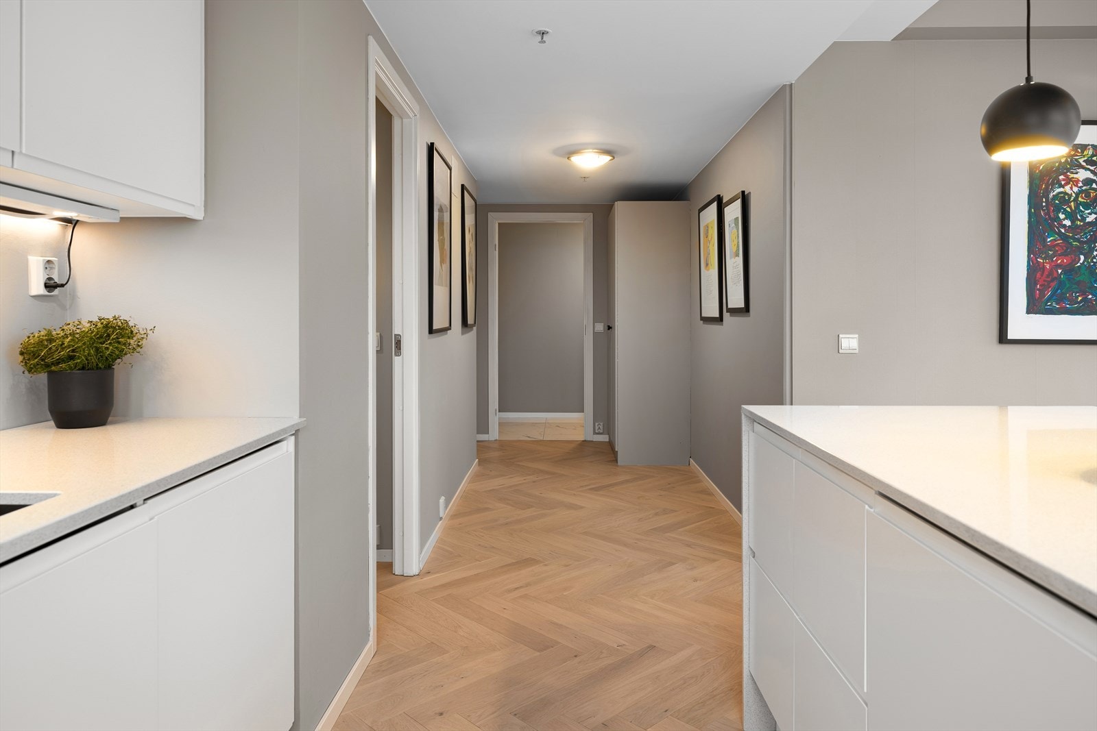 Innbydende gang som deler opp boligens øvrige rom. Gos plass til oppbevaring av klær og sko i praktisk garderobeskap. Galleribilde