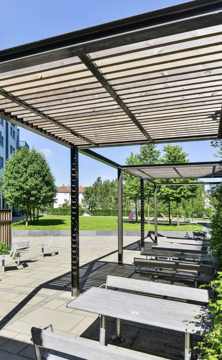 Idyllisk bakgård med sittegrupper, lekeplass og store grøntarealer. Galleribilde