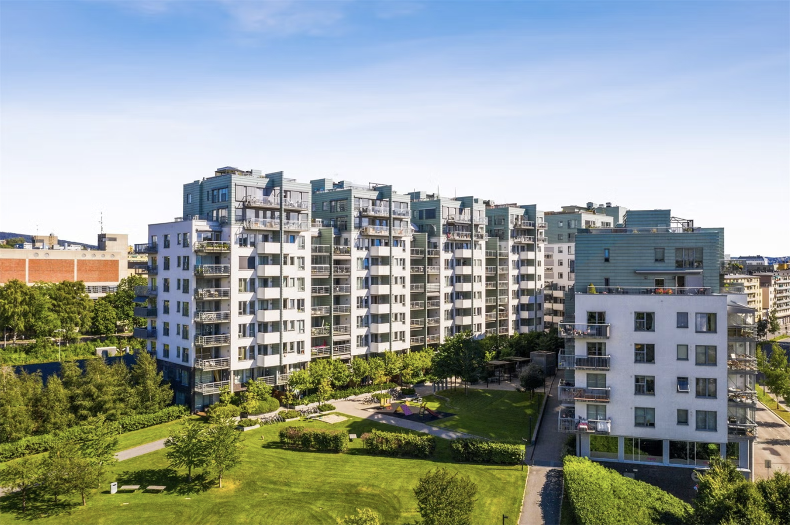 Idyllisk bakgård med sittegrupper, lekeplass og store grøntarealer. Galleribilde