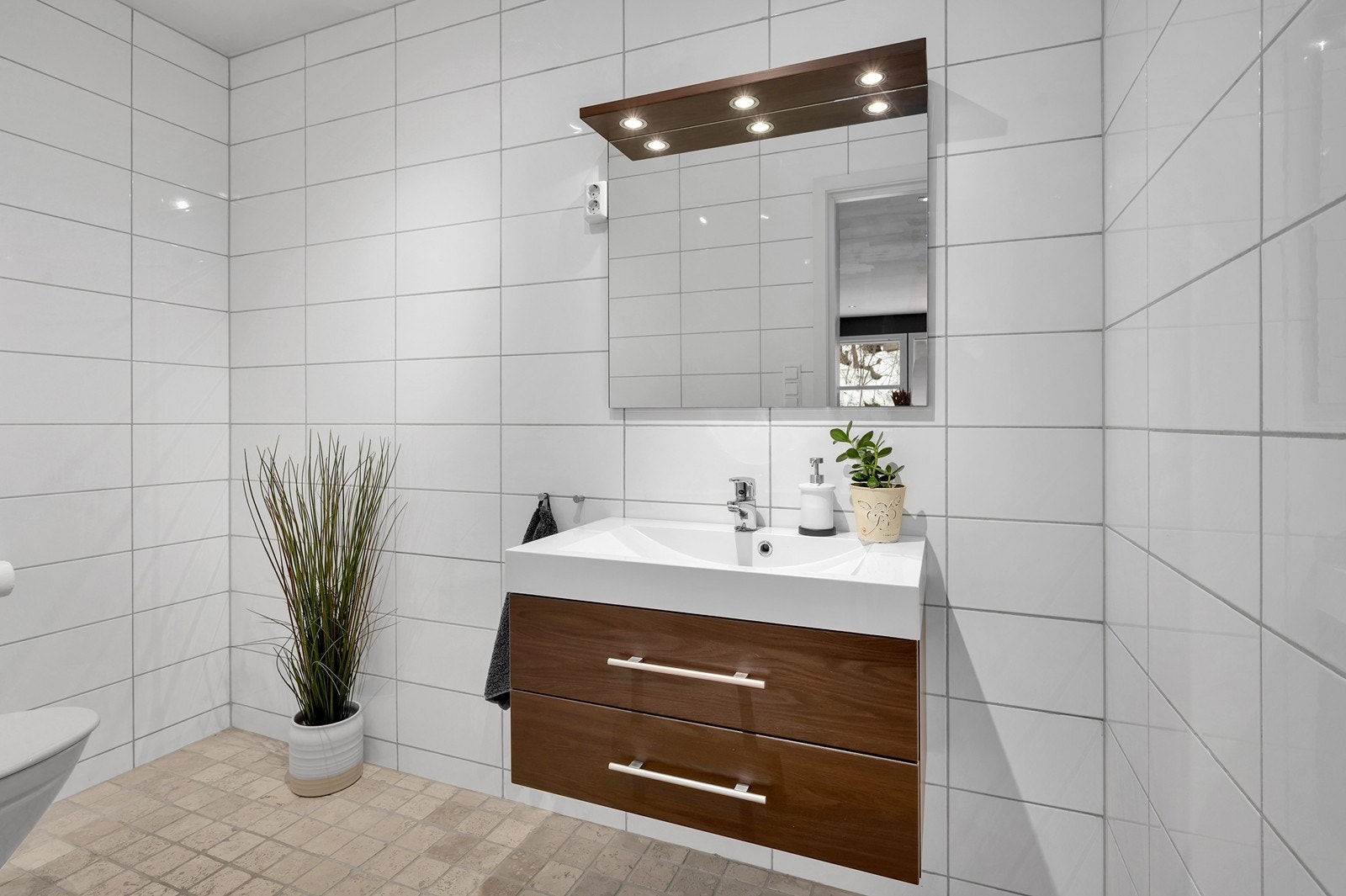 Etasjen byr også på et lekkert, flislagt bad/toalett utstyrt med servant med skuffer og vegghengt toalett. Galleribilde