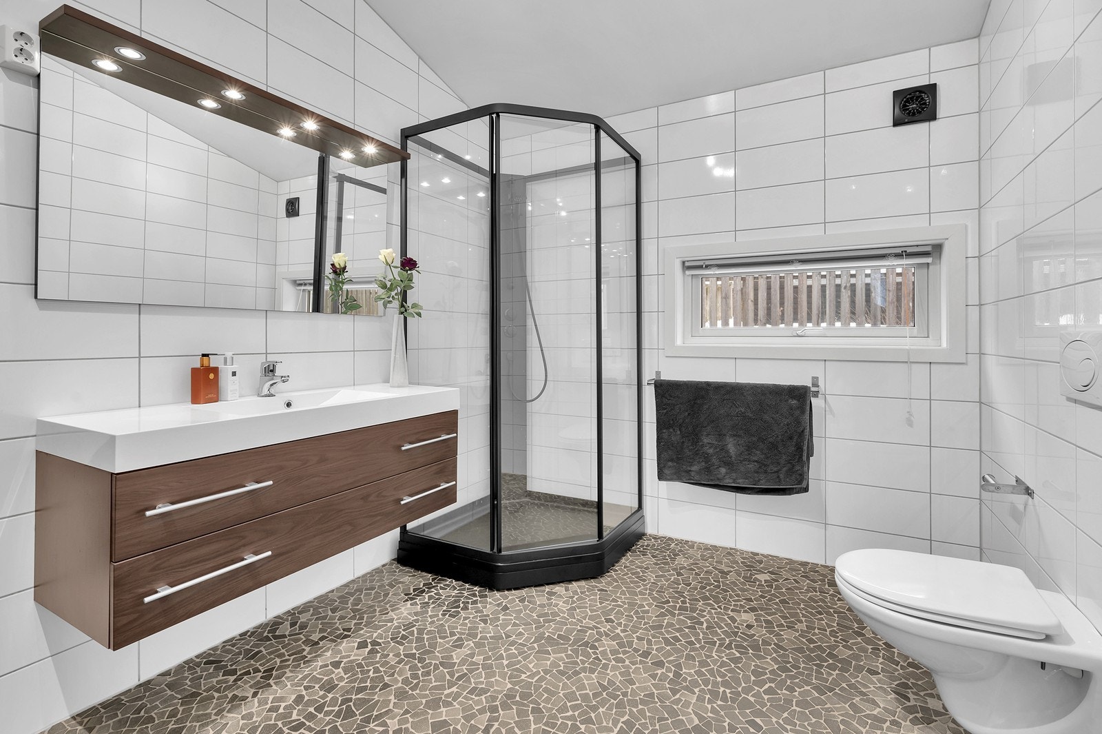 Hovedbadet er romslig og delikat innredet med dusjkabinett, vegghengt toalett og servant med skuffer. Galleribilde