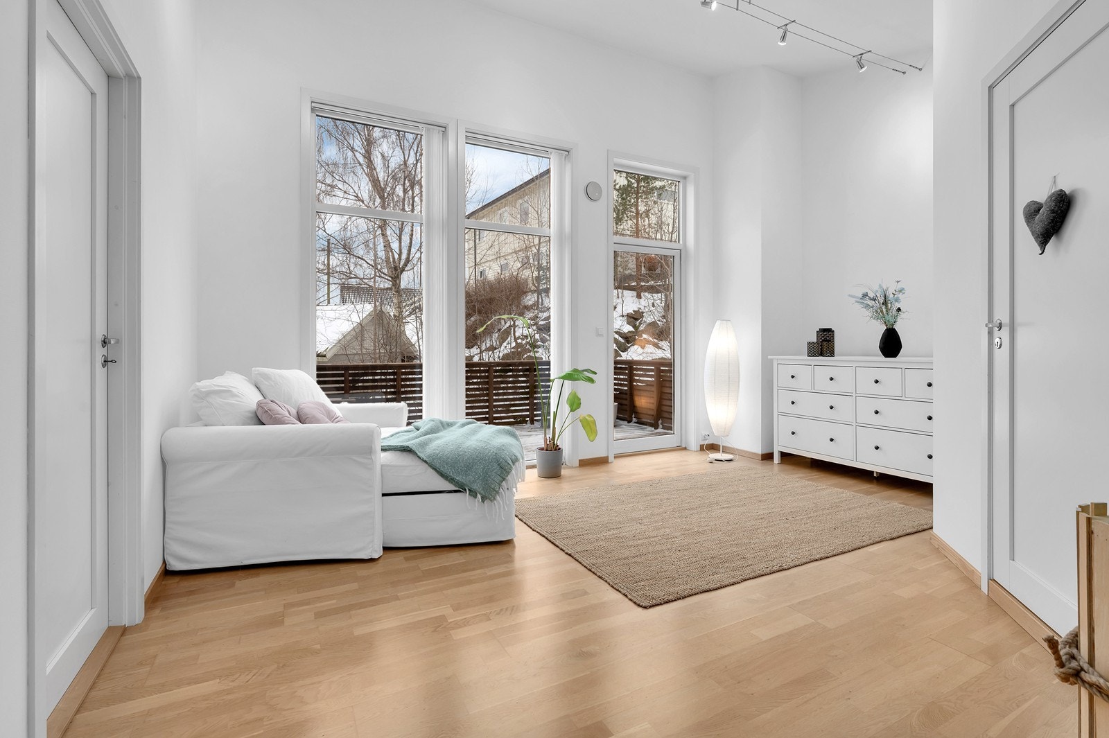 Lyse fargevalg og høye vinduer gir en god romfølelse. Her er det utgang til en solrik veranda. Galleribilde