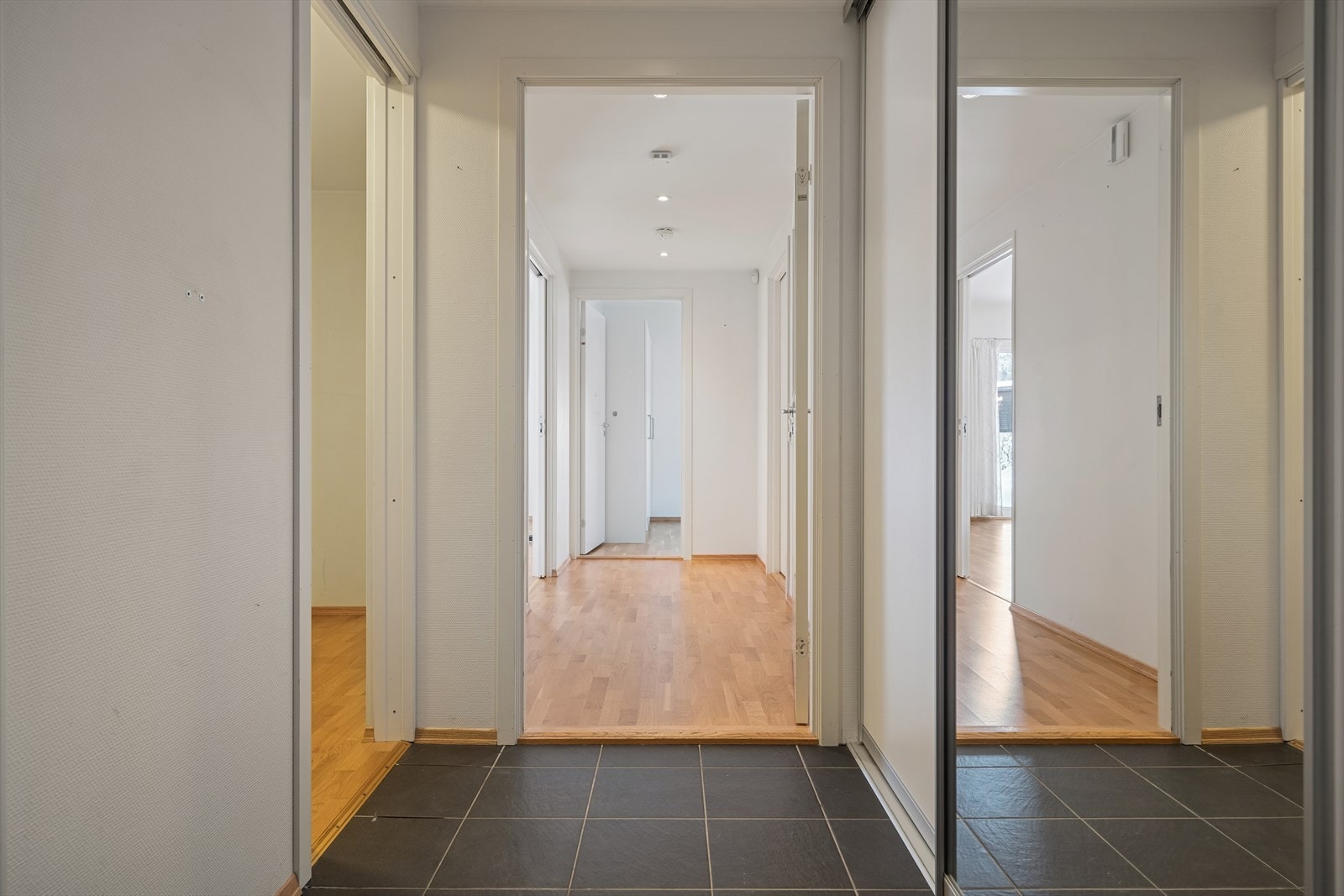 Flislagt gulv gir en praktisk og slitesterk entré. Skyvedørsgarderobe gir effektiv oppbevaring. Det er adkomst til en praktisk avlang innvendig og hvitmalt bod med gode lagringsmuligheter like ved entréen. Galleribilde