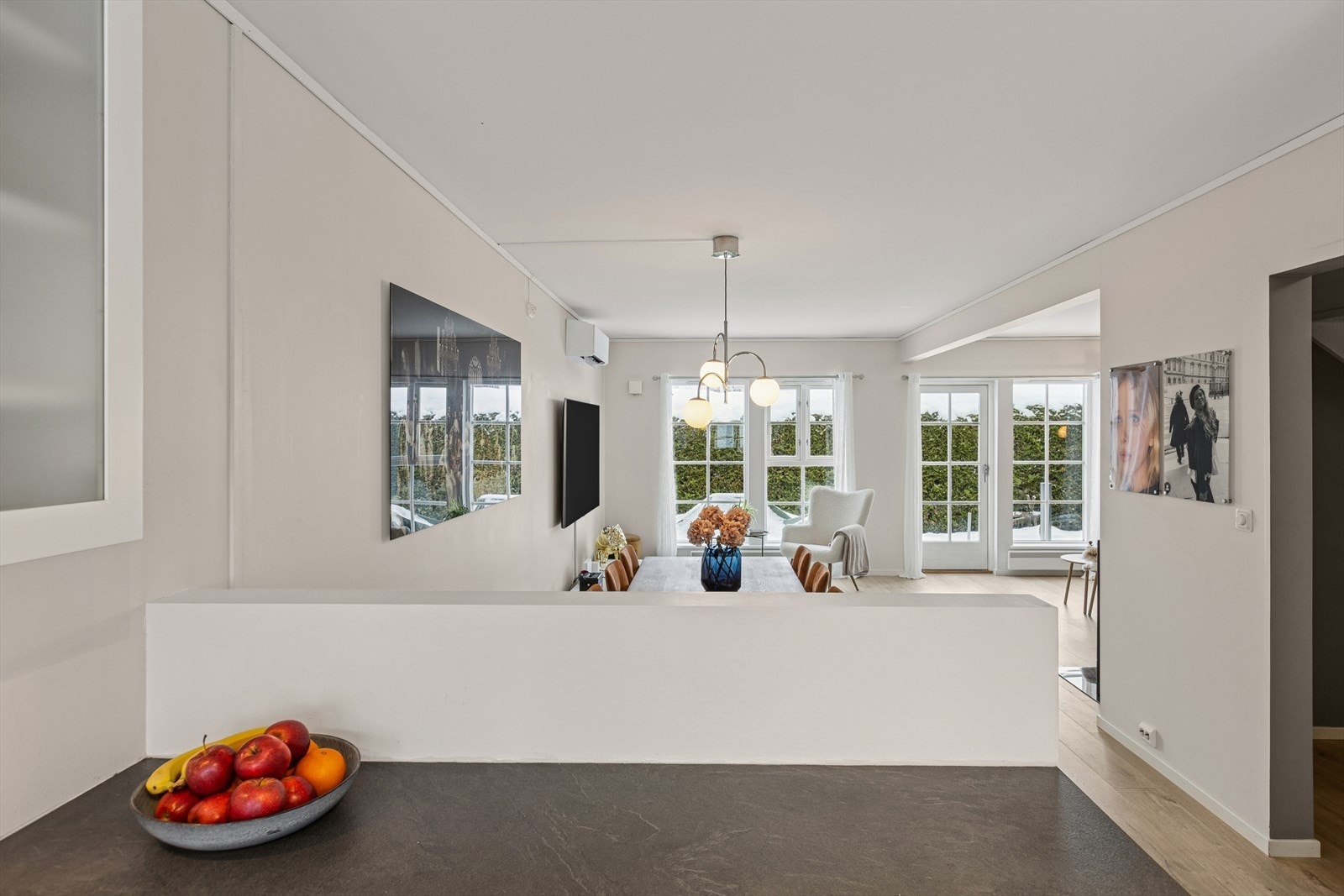 Utsyn fra kjøkkenet mot spisestuen og stuen gir en åpen og sosial atmosfære. Galleribilde