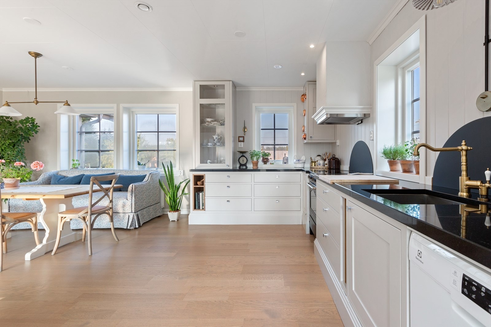 Hvit kjøkkeninnredning med hvite rammefronter og integrerte hvitevarer Galleribilde