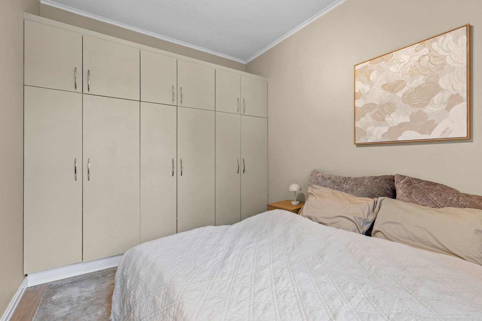 Det er en bred rekke med garderobeskap på soverom I Galleribilde