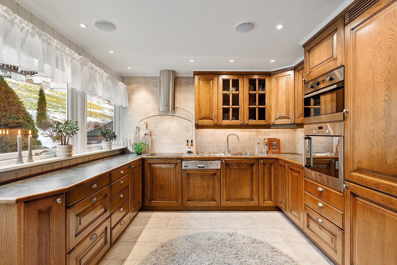 Kjøkkenet er innredet med mekanisk avtrekk over stekesone, integrert stekeovn, platetopp, oppvaskmaskin, mikro-ovn og kombinert kjøle-/fryseskap Galleribilde