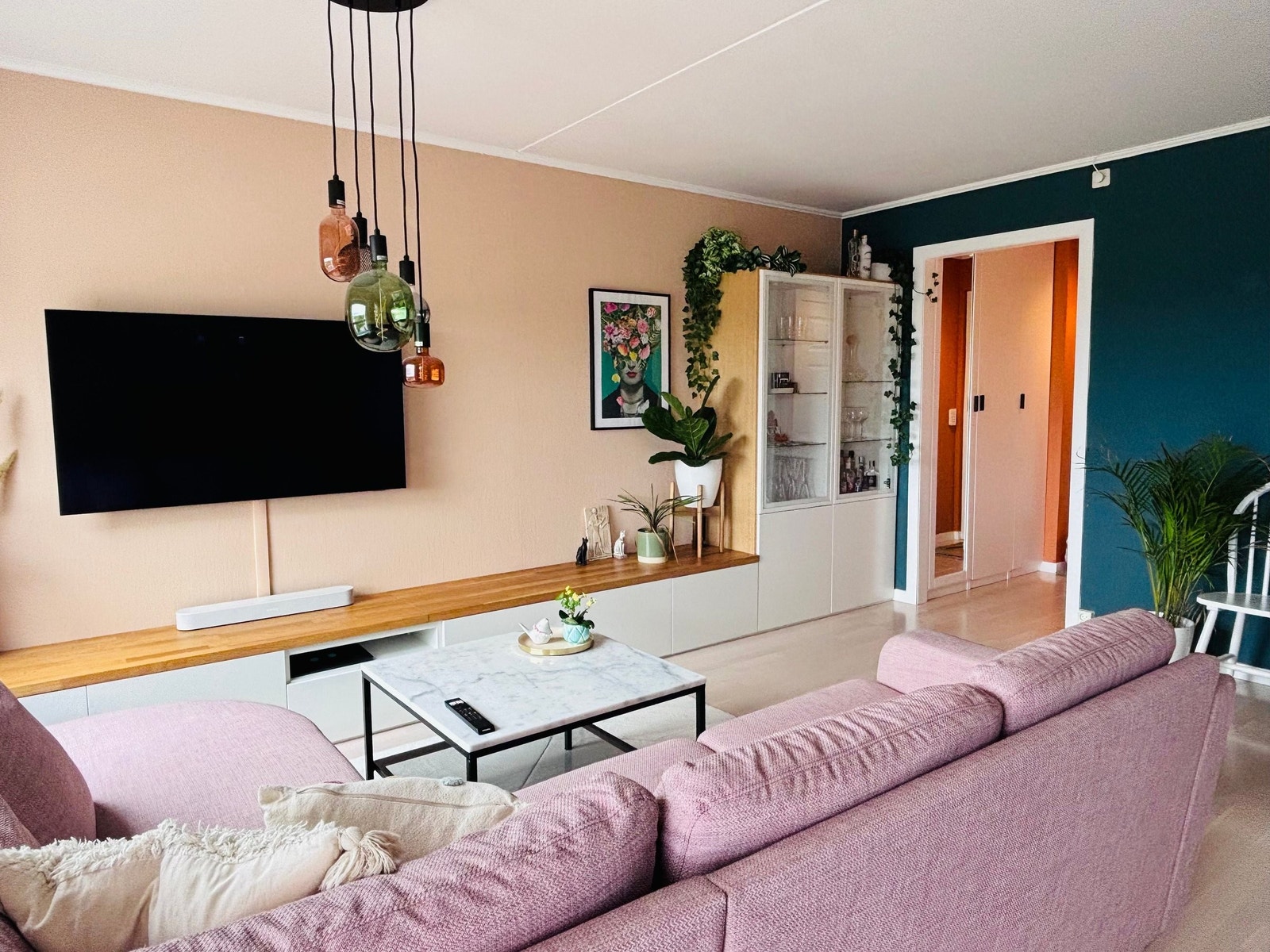 Plassbygget skuffeseksjon under TV, som også fungerer som en sitteplass Galleribilde