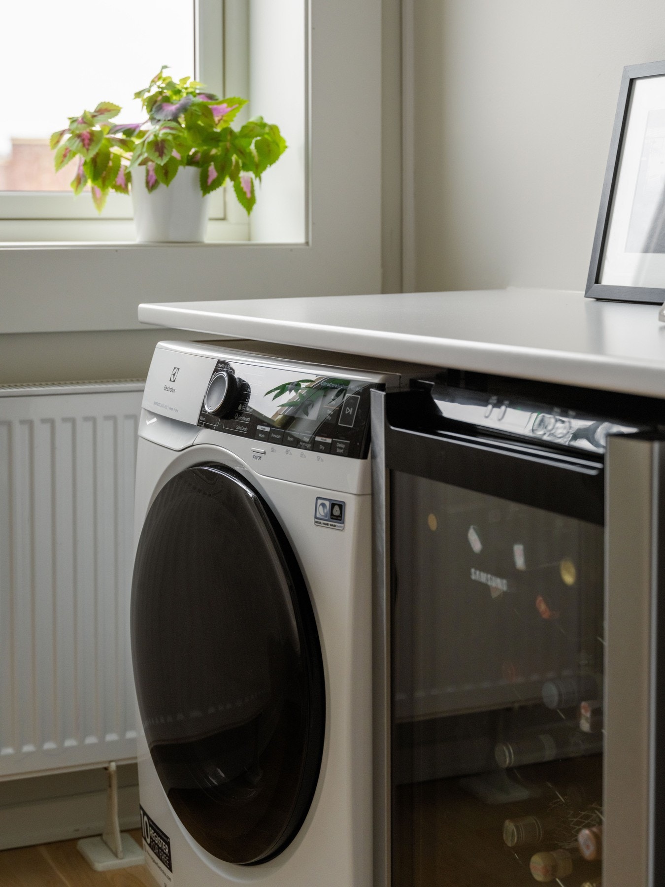 Under kjøkkenbenken er det plass og opplegg til vaskemaskin og vinskap. Det beste av to verdener, vil noen mene. Galleribilde