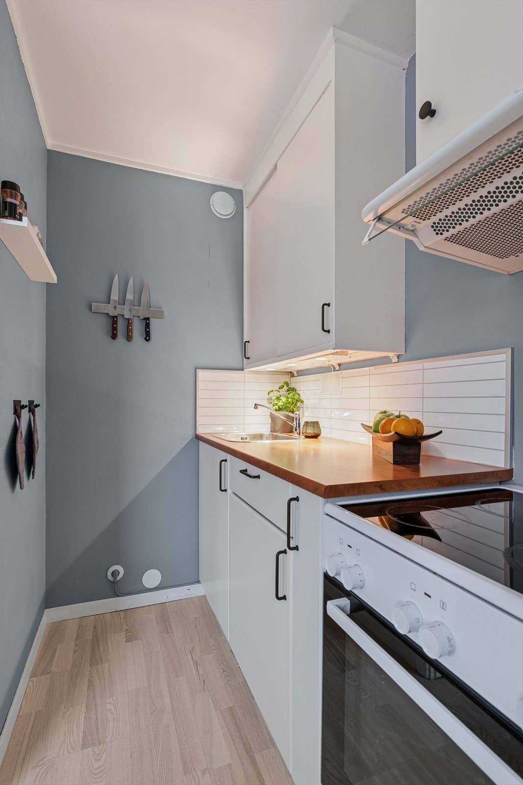 Over komfyren er det montert en kjøkkenvifte med avtrekk ut. Galleribilde