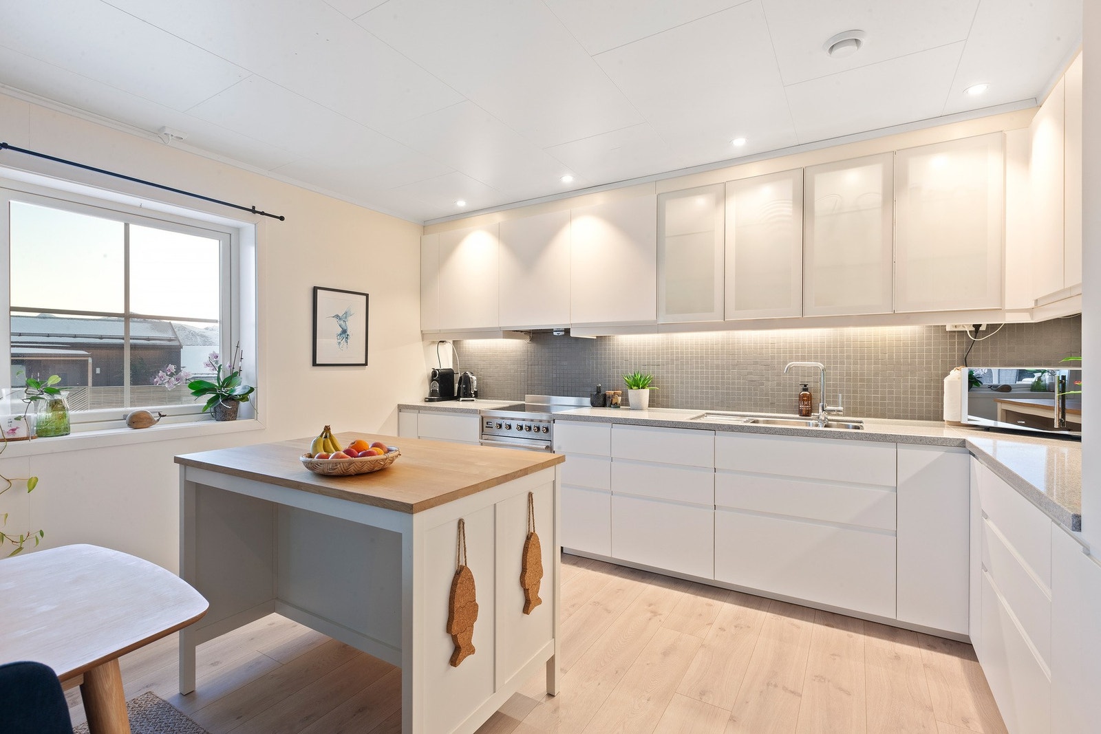 Romslig kjøkken utført i hvite fronter med god skap-og benkeplass. Galleribilde