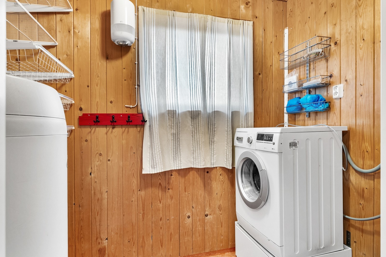 Det er eget vaskerom i boligen med vinylbelegg på gulv og panelte vegger. Galleribilde