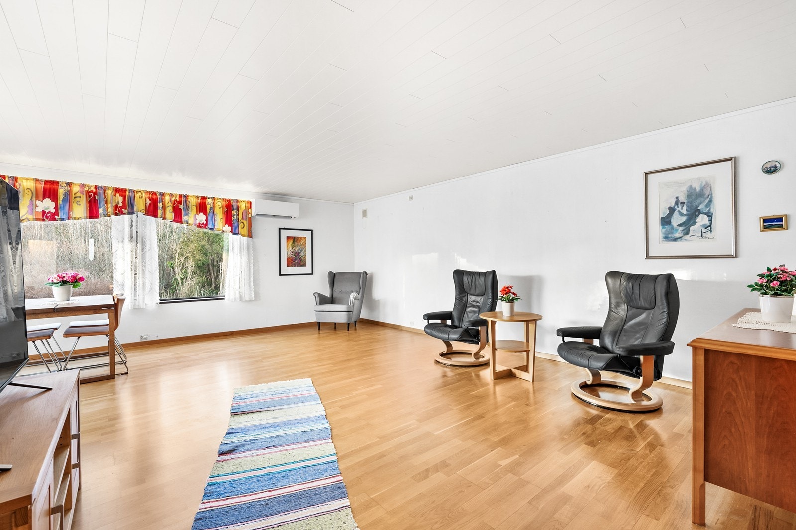 Stuen er romslig med god plass til å plassere stor salong, spisegruppe og annet ønsket møblement Galleribilde