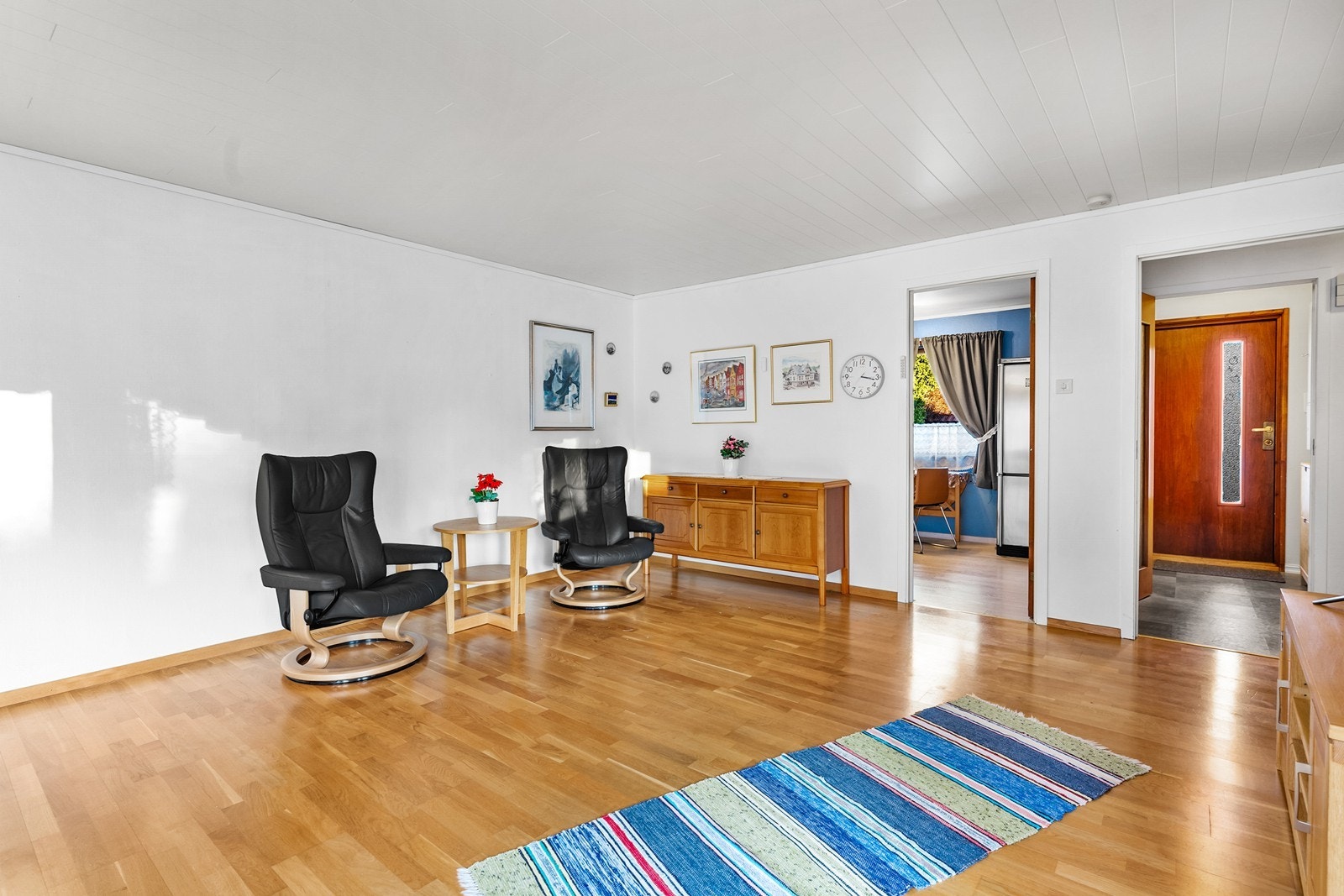 Romslig stue med dør inn til kjøkken Galleribilde