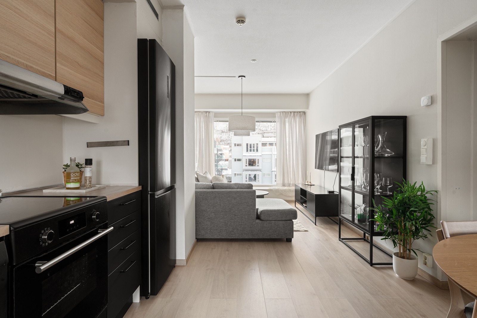 Stue og kjøkken er adskilt i forskjellige avdelinger, samtidig som det er åpent - noe som gir gjennomlys i rommet.