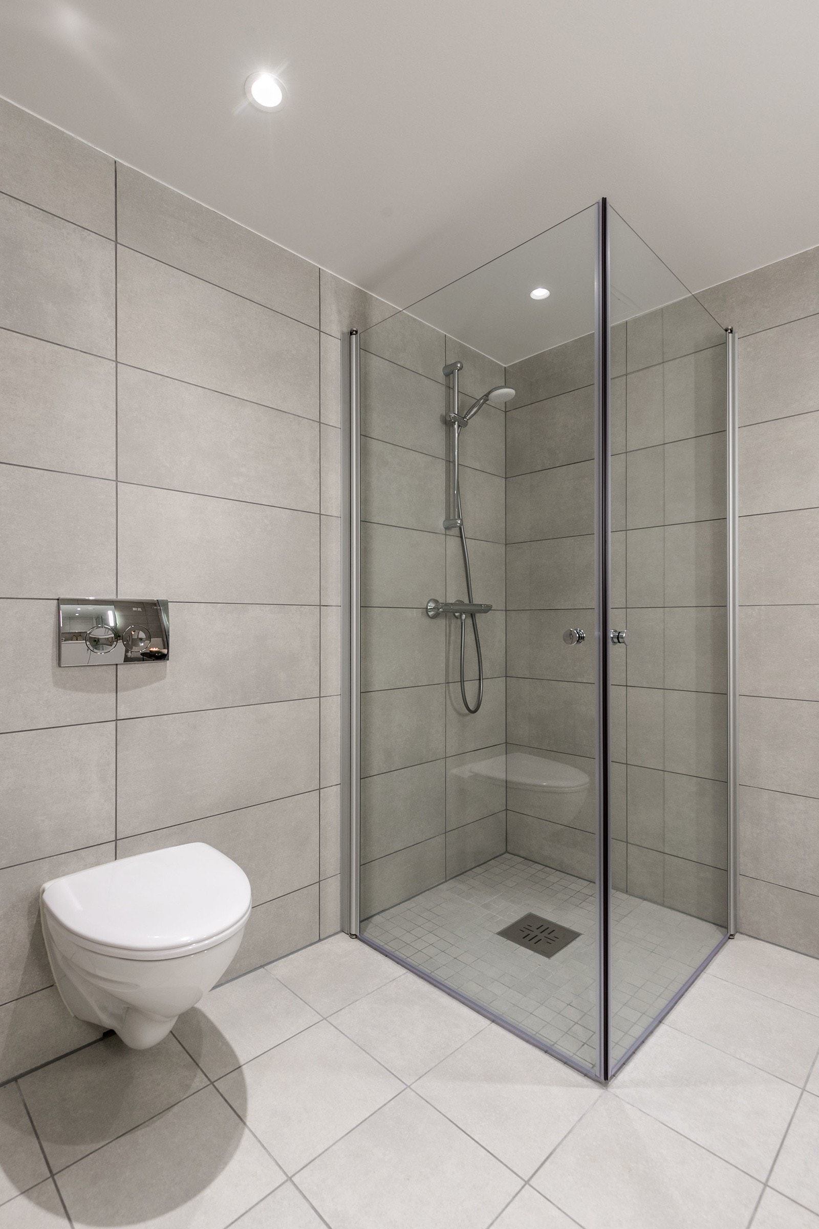 Badet har vegghengt toalett med innbygget sisterne, servant med skapinnredning samt speil med belysning. Bilde fra M504 Galleribilde