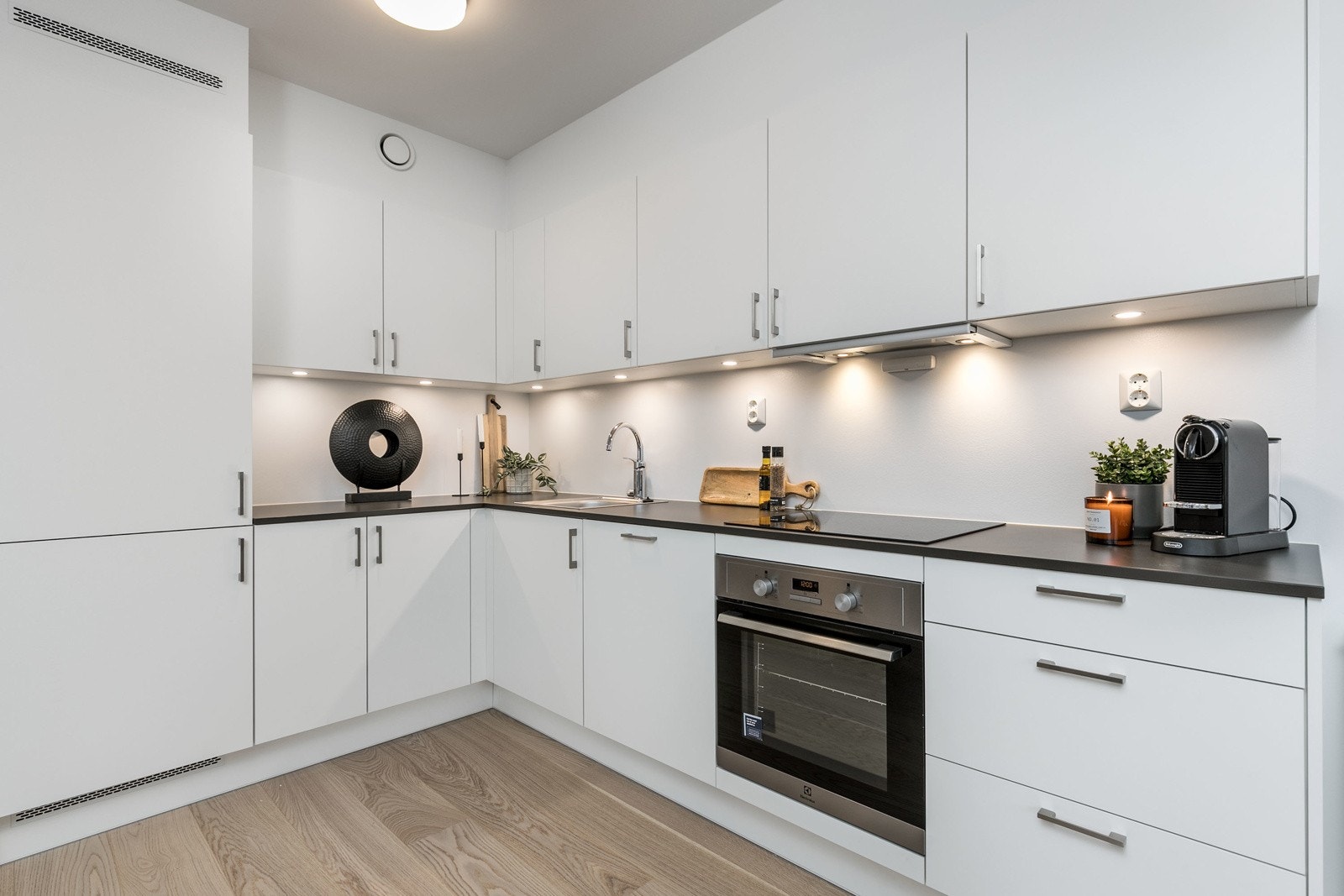 Kjøkkenet har integrert kjøl/frys, ovn, steketopp, oppvaskmaskin og uttrekkbar vifte. Belysning under skapinnredning. Bilde fra M504 Galleribilde