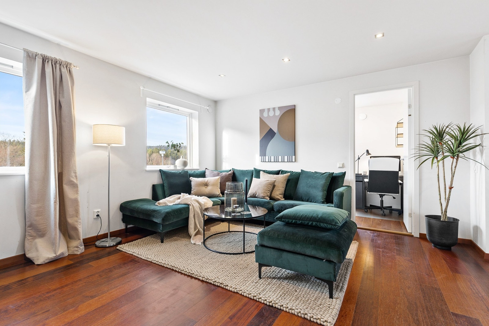 Stuen er lys og luftig, med vinduer som fyller rommet med naturlig dagslys. Galleribilde