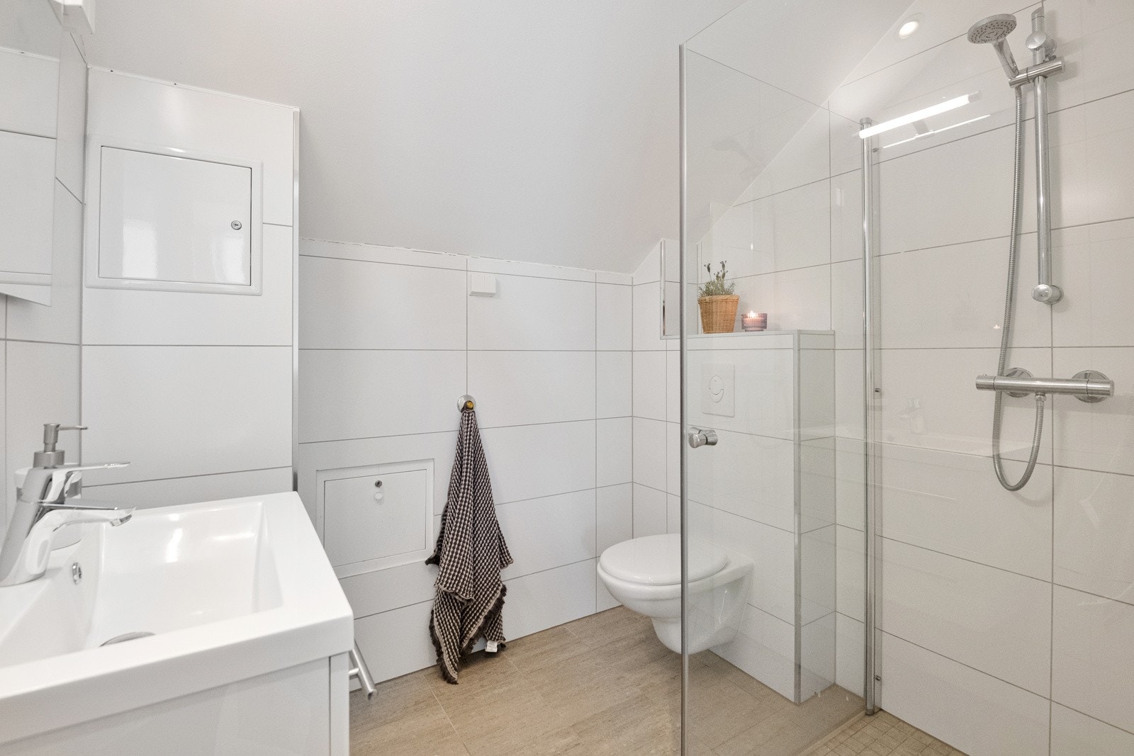 Også badet i 3. etg er fra 2018 med flislagte vegger og gulv med varmekabler. Himlingen er malt og utstyrt med integrerte spotlights. Badet er innredet med servant, toalett, dusjinnredning med glatte overflater og et speil med innebygd lys. Galleribilde