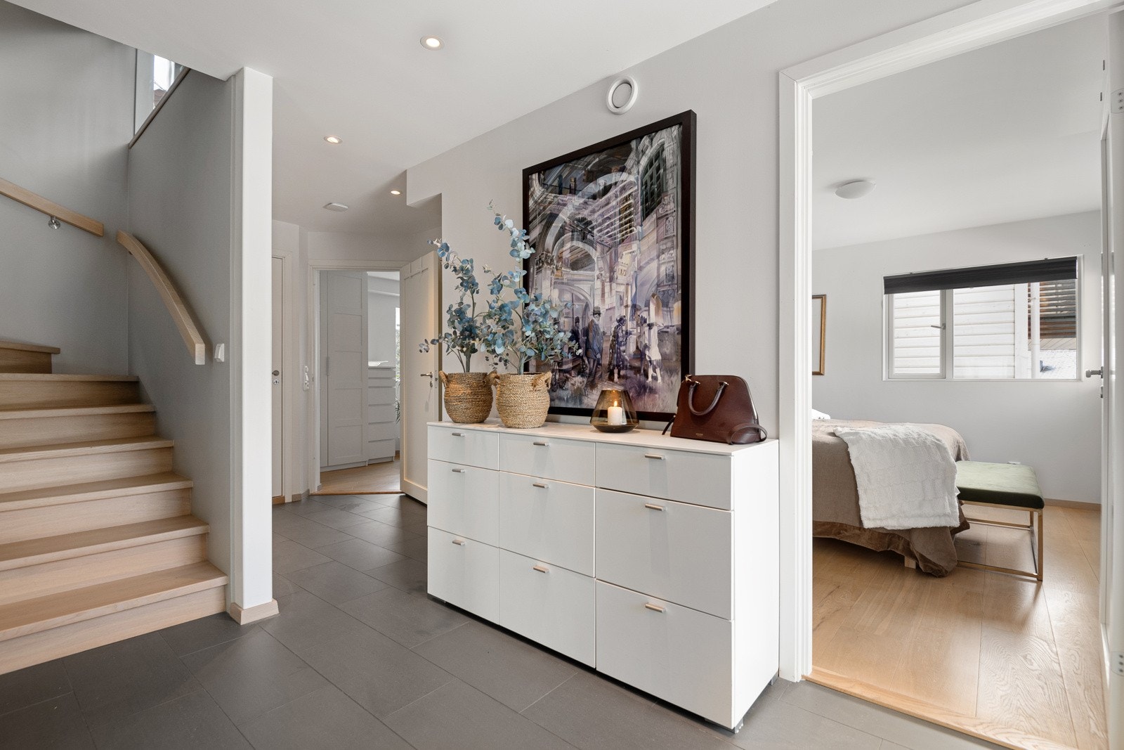 Entréen glir sømløst over i gangen/trapperommet, og er også tilknyttet soverom. Her er det også plass til en romslig kommode. Galleribilde