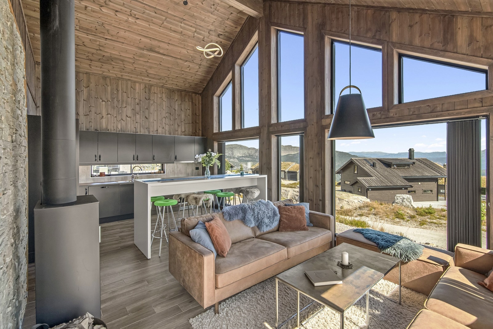 Hytten har store vindusflater som slipper naturen inn, smakfull innredning og løsninger som gir høy komfort året rundt. Galleribilde