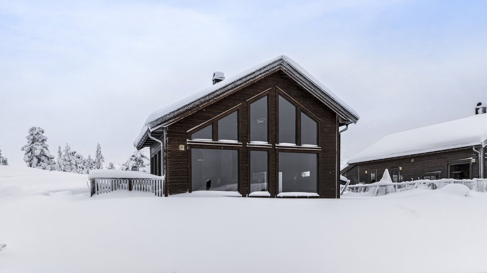 Flott og moderne hytte med store vindusflater og åpen himling inne Galleribilde