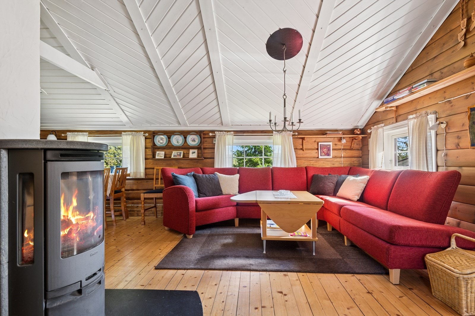 Koselige sprossevinduer sender dagslyset inn og bidrar til en lett og luftig romatmosfære. I tillegg bidrar beisede tømmervegger og lakkerte tregulv til den lune og gode hyttefølelsen. Galleribilde