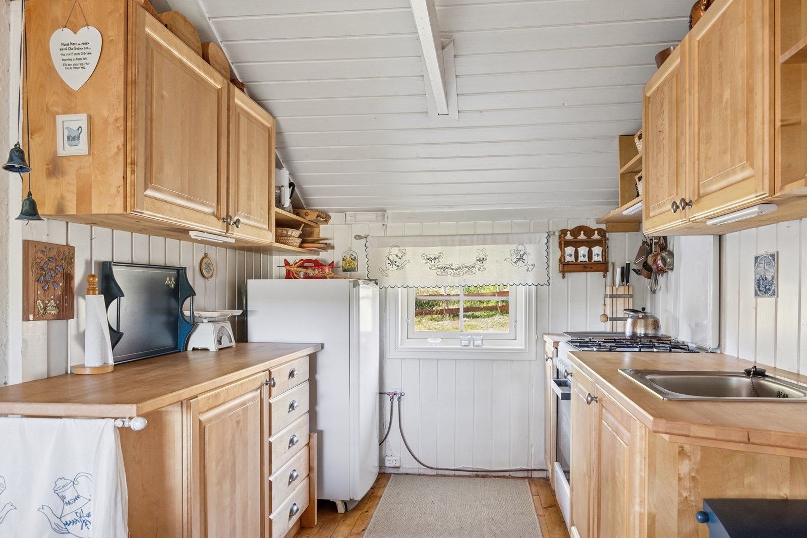 Innredningen består av både over -og underskap, og i rommet er det plass for frittstående gasskomfyr og gasskjøleskap. Galleribilde