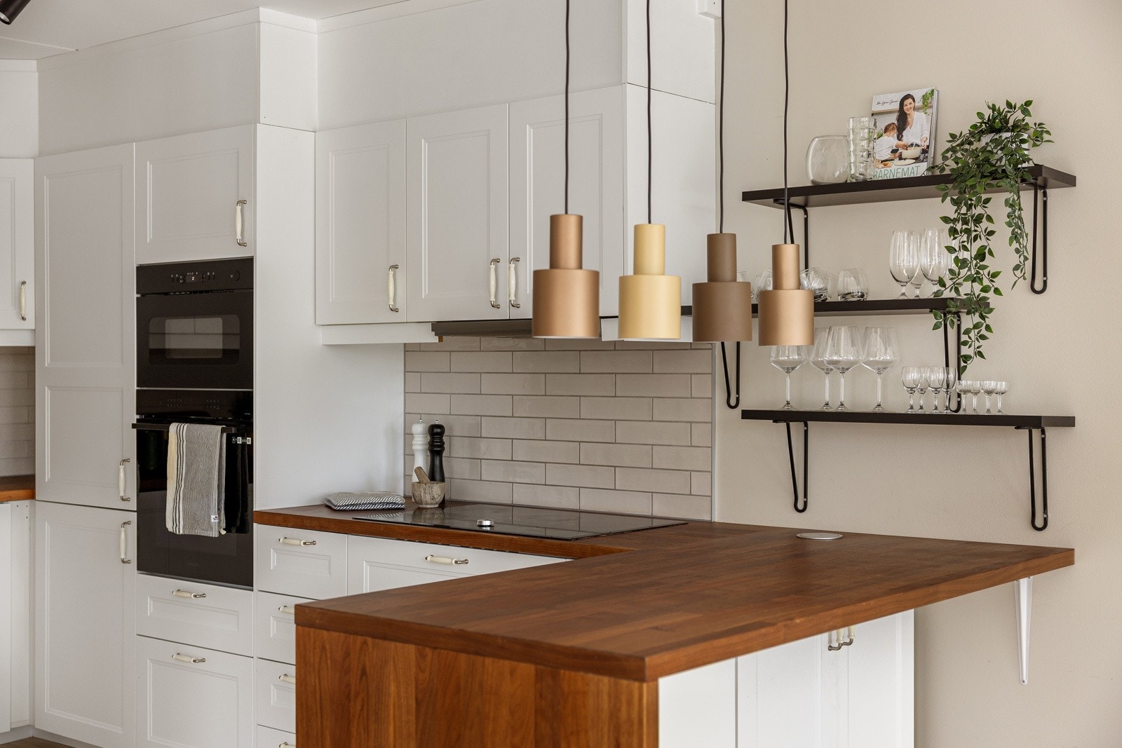 Kjøkkenet har en praktisk utforming med en halvøy som sørger for ekstra god skap- og benkeplass, samt en hyggelig sitteplass med barstoler. Galleribilde