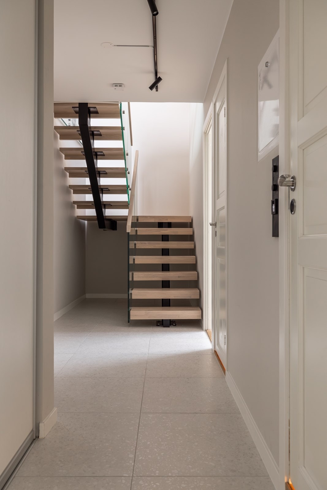 Stilren repotrapp med glass som leder til stue og kjøkken. Galleribilde