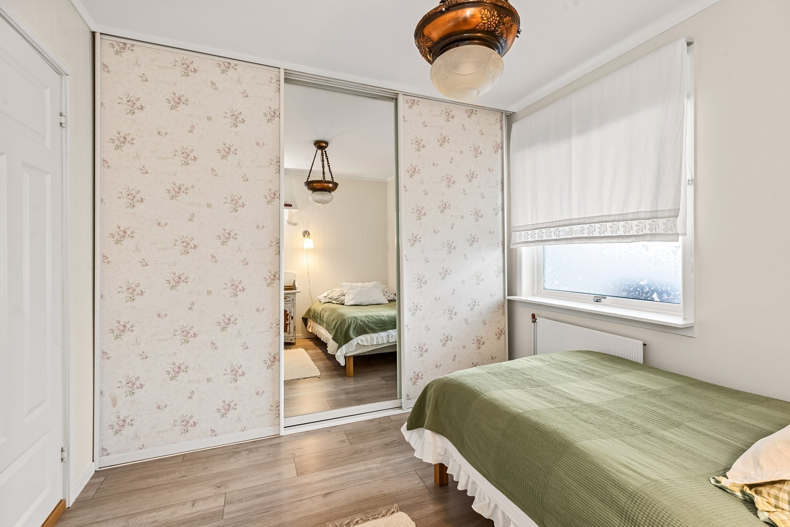 Hovedsoverommet er luftig med hvitmalt panel og fin vindusflate. Galleribilde