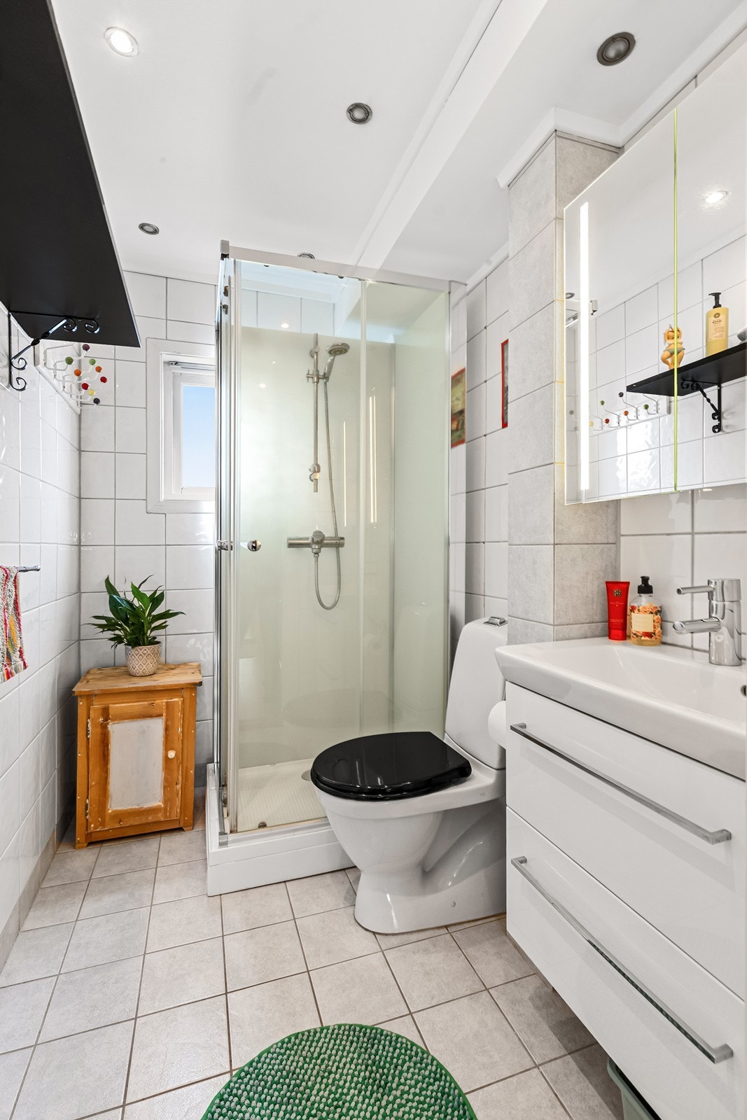 Badet er utstyrt med toalett, servant med skuffer og dusjkabinett. Galleribilde