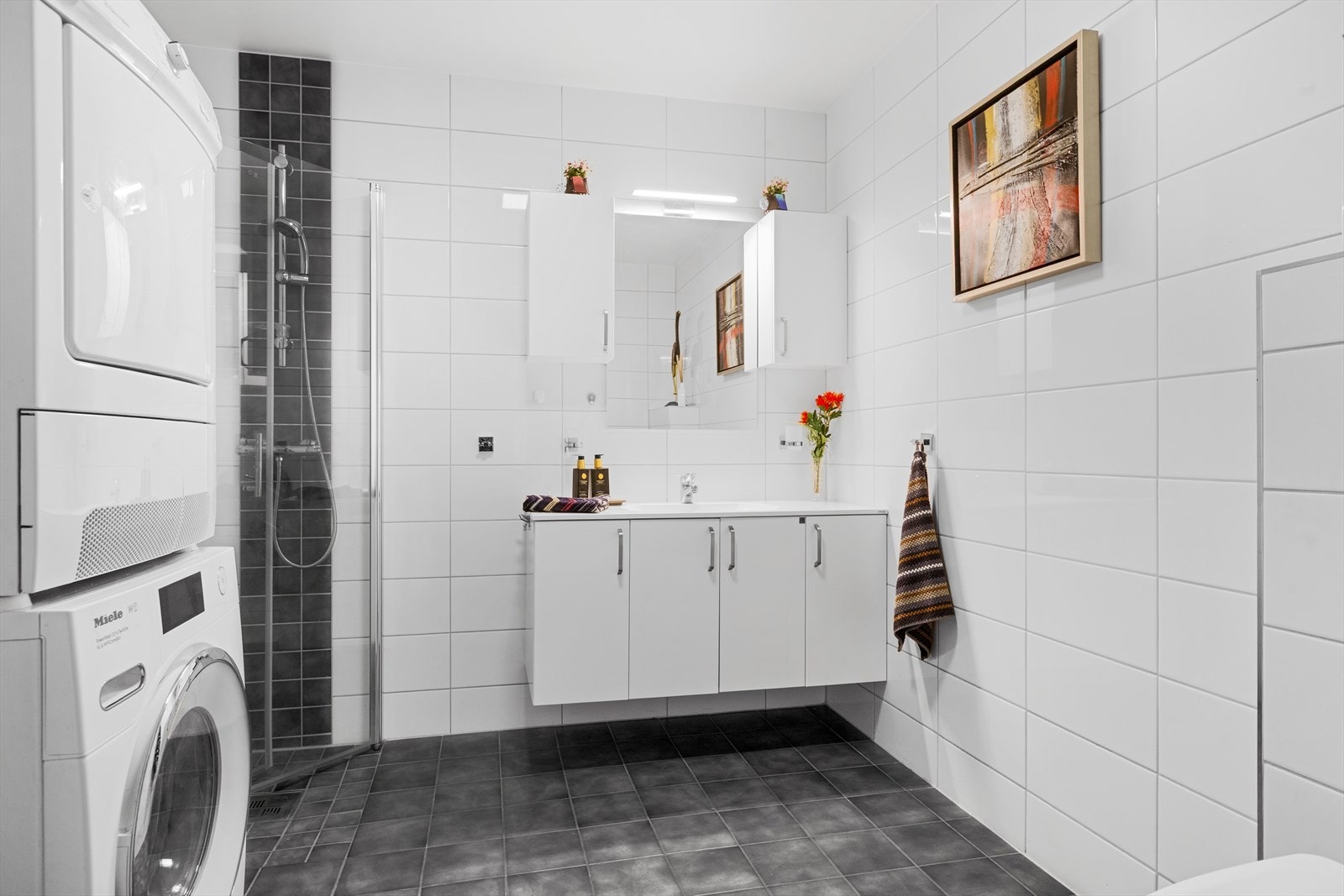 Badet i første etasje er helfliset og utstyrt med dusjhjørne og opplegg for vaskesøyle. Galleribilde