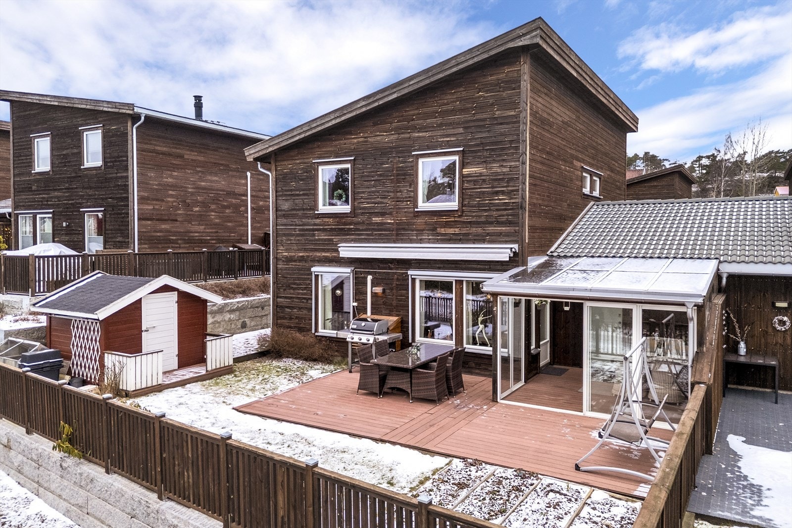 Hage med plen og beplantninger som er avgrenset med gjerde som står i god stil til boligen. Galleribilde