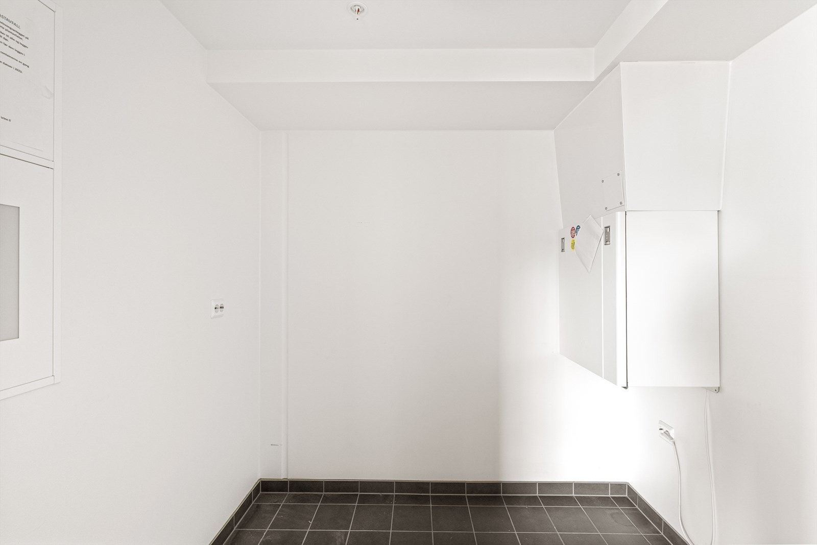 Romslig flislagt vaskerom med gode lagringsmuligheter. Galleribilde