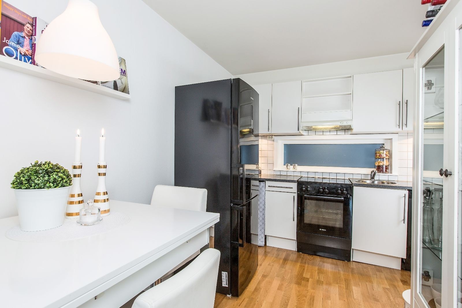 Kjøkken med kombiskap, komfyr og oppvaskmaskin. Galleribilde