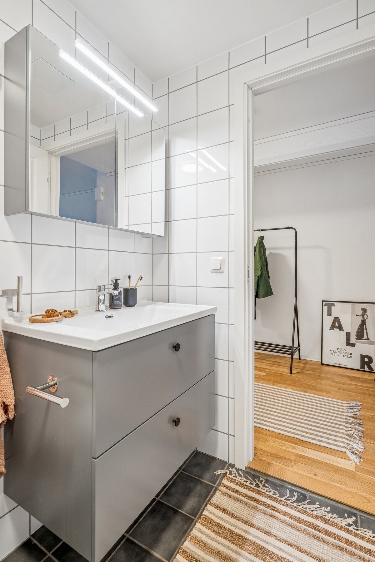 Klassisk badromsinnredning med nedfelt servant, speil med overbelysning, dusjnisje og WC. Galleribilde