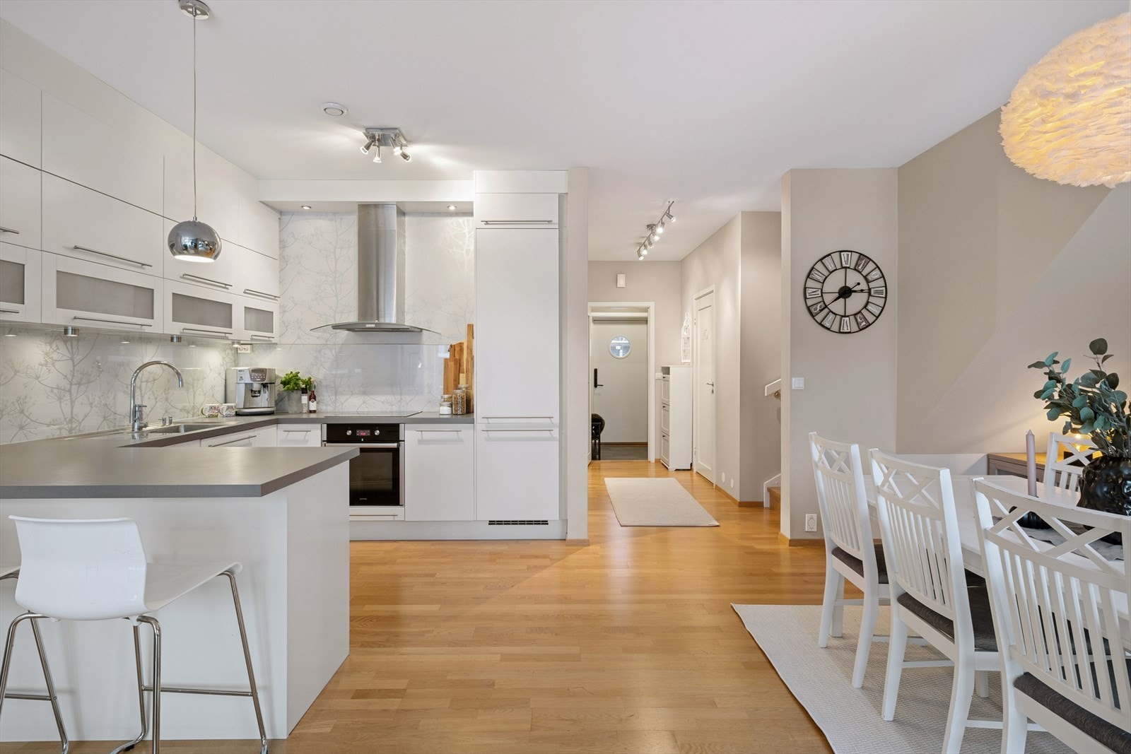 Den åpne løsningen mot en hyggelig stue og romslig spisestue gir en sosial og luftig atmosfære, og gjør dette til et kjøkken som virkelig inviterer til både hverdagsbruk og hyggelige sammenkomster. Galleribilde