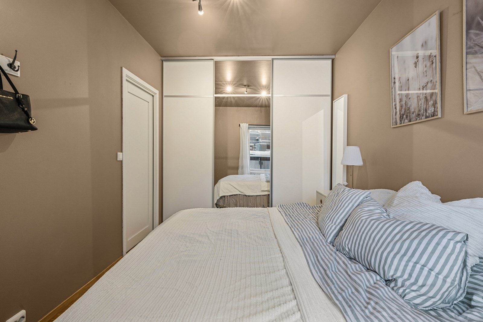 Praktisk garderobeløsning med skyvedører gir godt med oppbevaringsplass, og en av dørene har speil som både er funksjonelt og gir en følelse av ekstra romslighet. Galleribilde