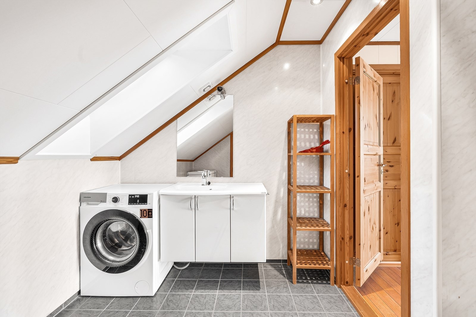 Bad innredet med nedfelt servant, veggmontert toalett og dusjkabinnet. Vaskemaskin medfølger. Galleribilde