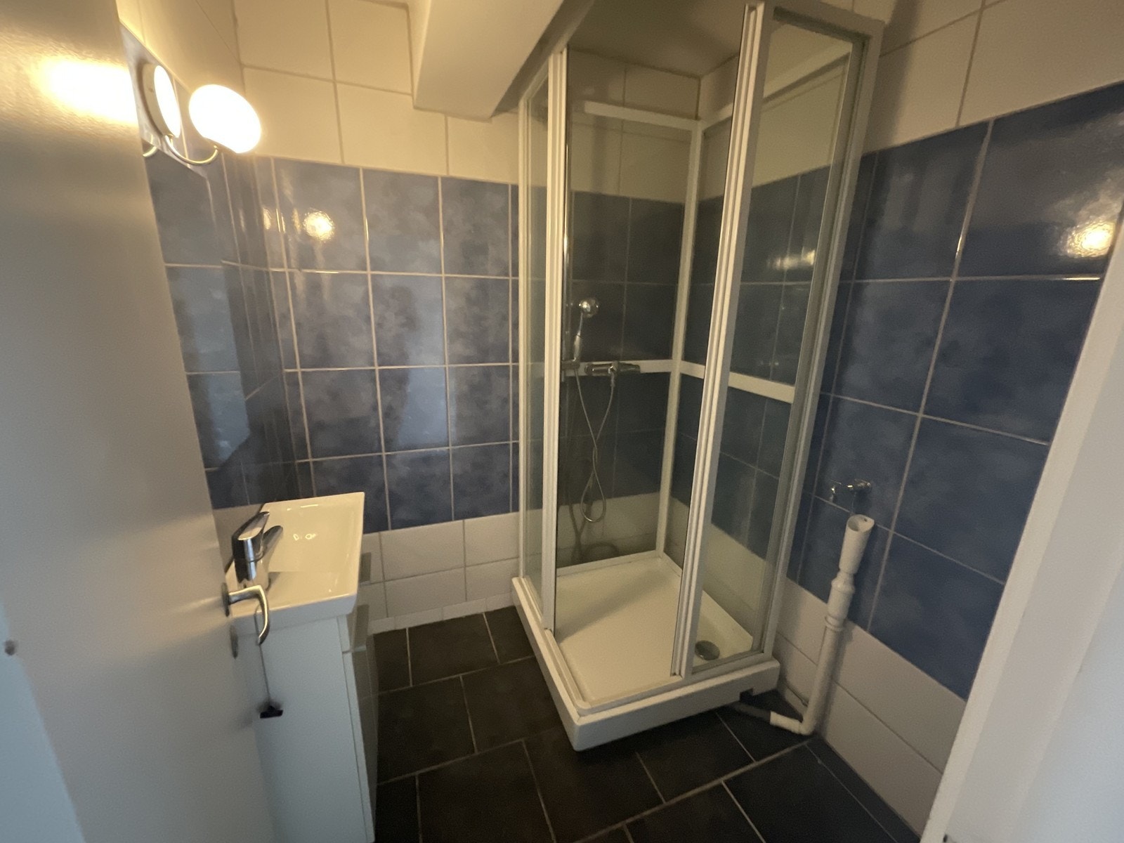 Flislagt bad med dusjkabinett, servant m/innredning og opplegg for vaskemaskin. Galleribilde