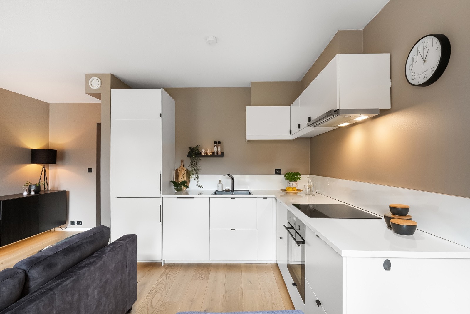 Sosialt og lekkert kjøkken fra 2017-2019 med hvite, slette fronter, benkeplate av laminat og god skap- og benkplass. Galleribilde