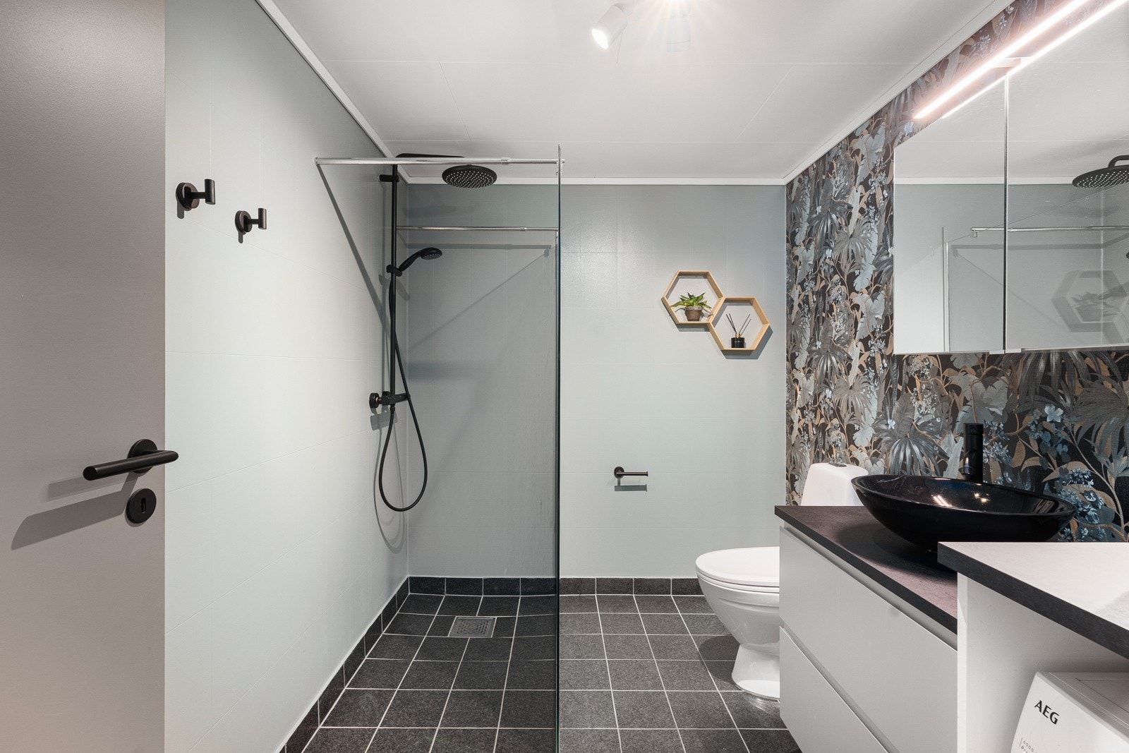 Flott bad med fliser på gulv samt varmekabler som bidrar til ekstra komfort i hverdagen og mer energieffektiv oppvarming. Galleribilde