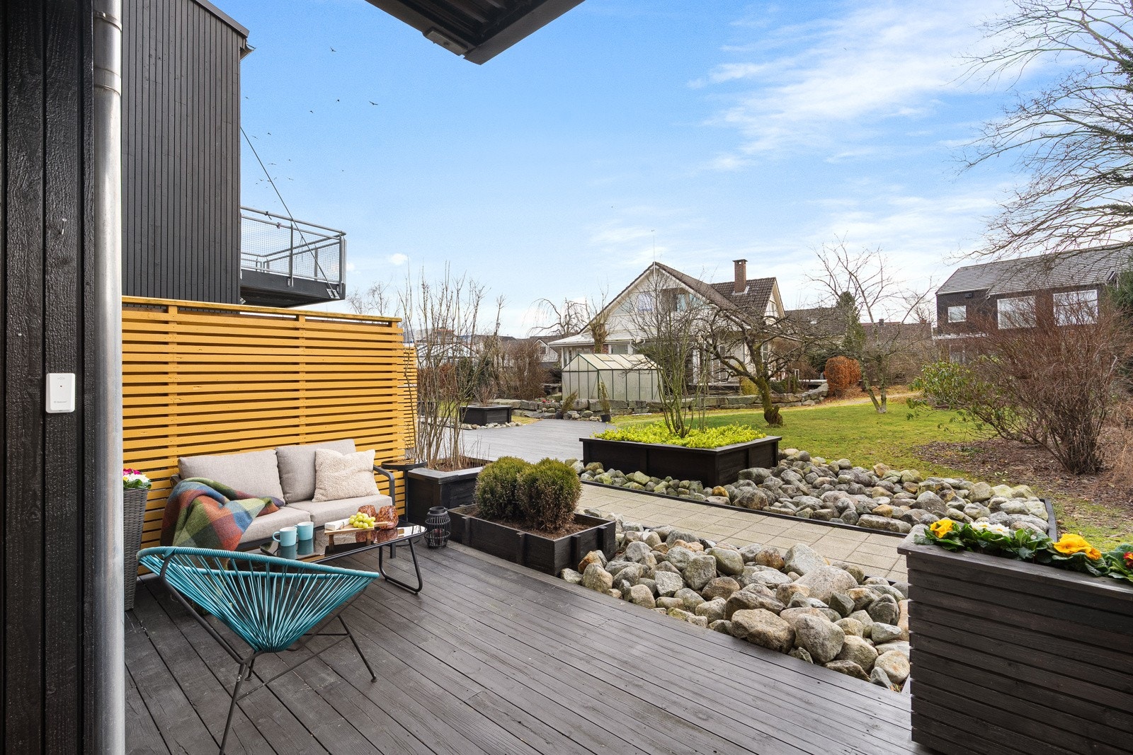 Flott utsyn mot frodig fellesareal, pent opparbeidet med steinbelagt gangsti, plen og rikelig beplantning. Galleribilde