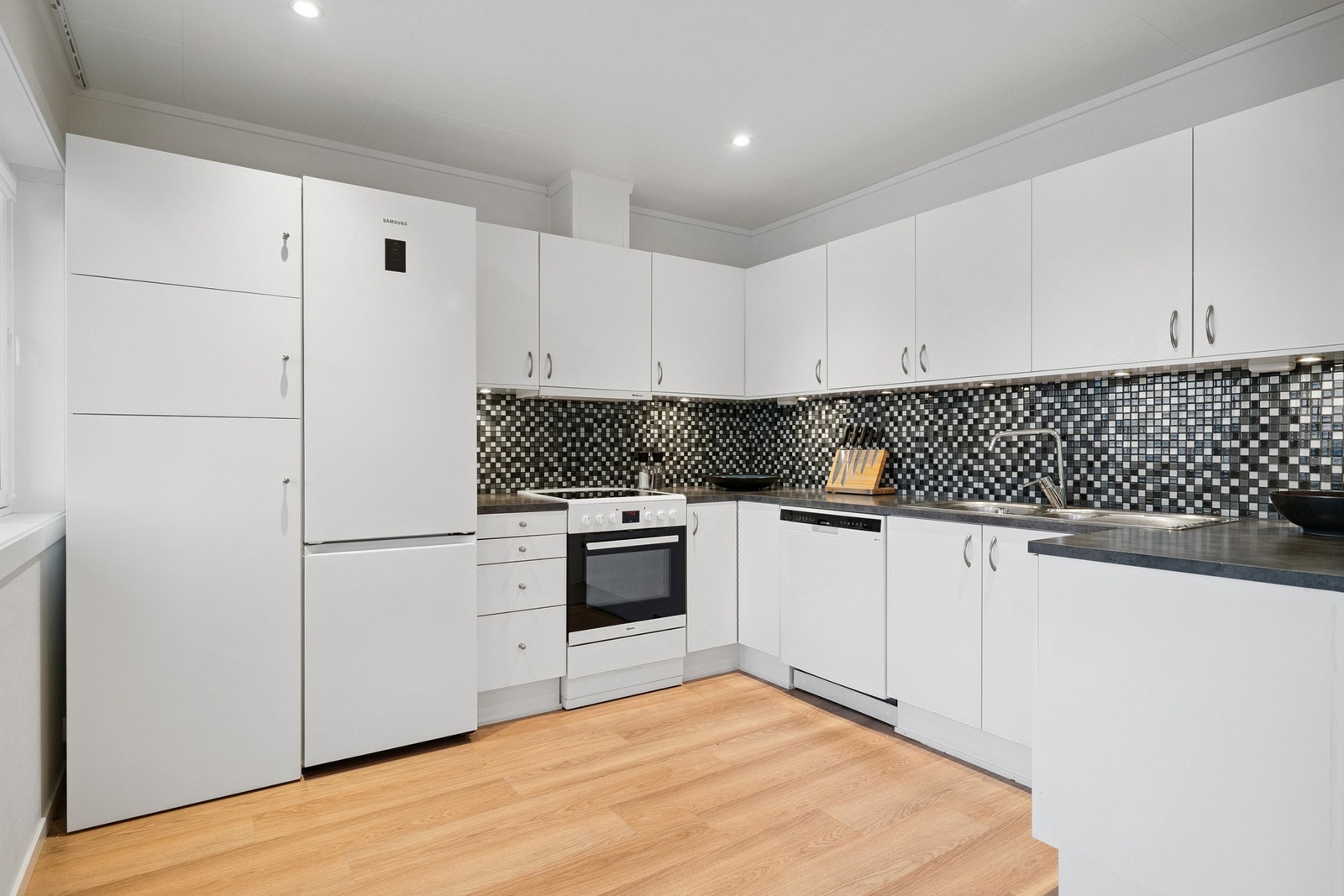 Kjøkkeninnredning med godt med skap- og benkeplass Galleribilde