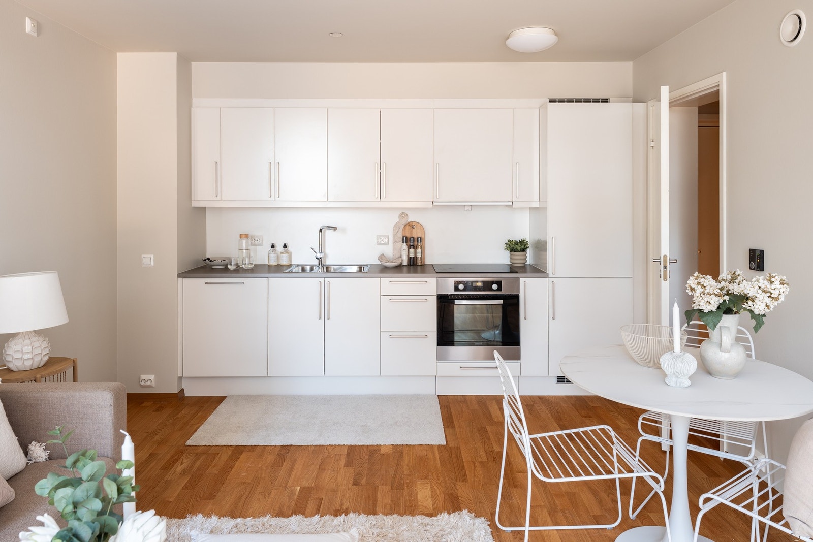 Praktisk og stilsikker stue og kjøkkenareal i åpen løsning. Parkettgulv og tidløst kjøkken. Galleribilde