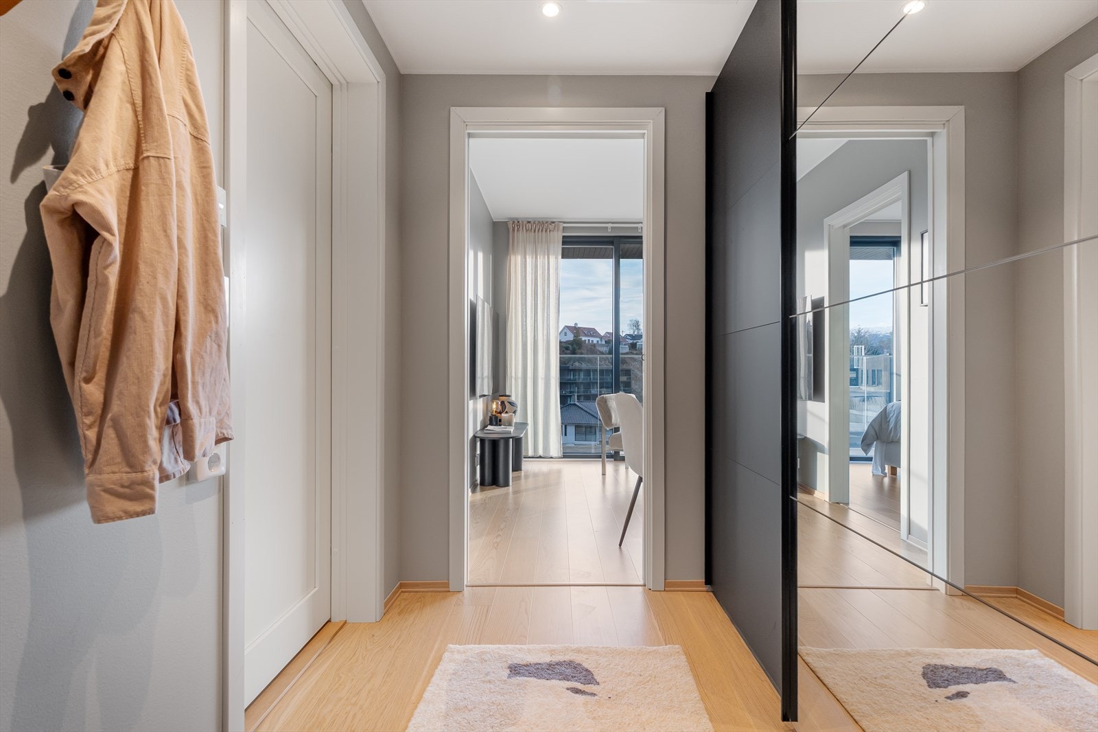 En innbydende entré med stort garderobeskap som leder inn mot stuen. Galleribilde