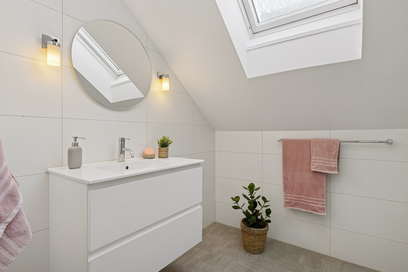 Badet i loftsetasjen ble oppgradert i 2018 og fremstår moderne, delikat og funksjonelt. Rommet har flislagte overflater på både vegger og gulv, kombinert med malt himling, noe som gir en helhetlig og tidsriktig fremtoning. Galleribilde